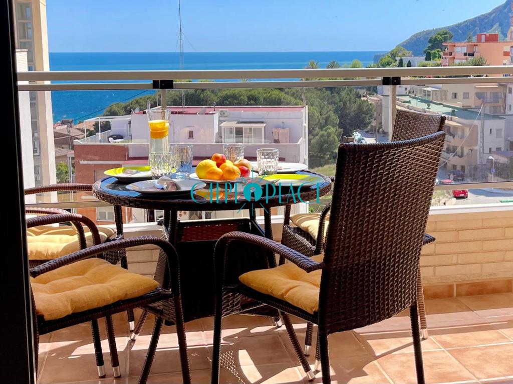 a table with a bowl of fruit on a balcony at MENTA Apto. con piscina a solo 200m de la playa in Calpe