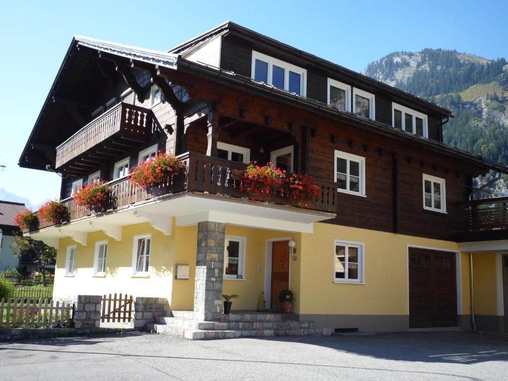 ein Haus mit einem Balkon mit Blumen darauf in der Unterkunft Haus Radona in Wald am Arlberg