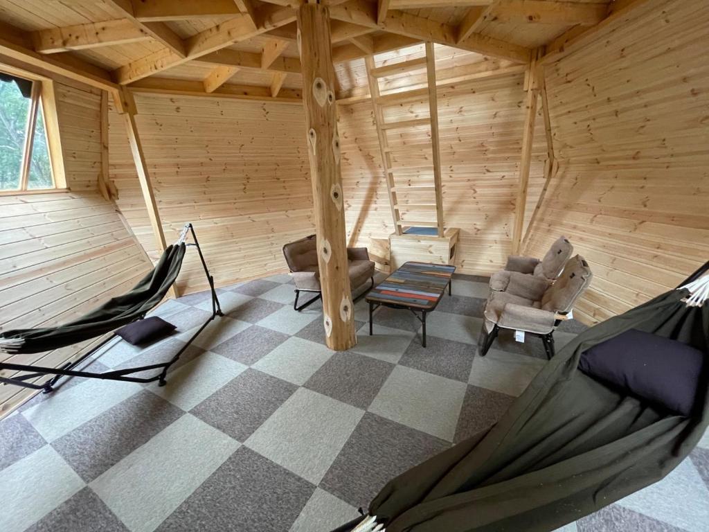 North Villge Hirugano - Vacation STAY 21286v في غوجو: غرفة مع اثنين من الأراجيح في كابينة خشبية