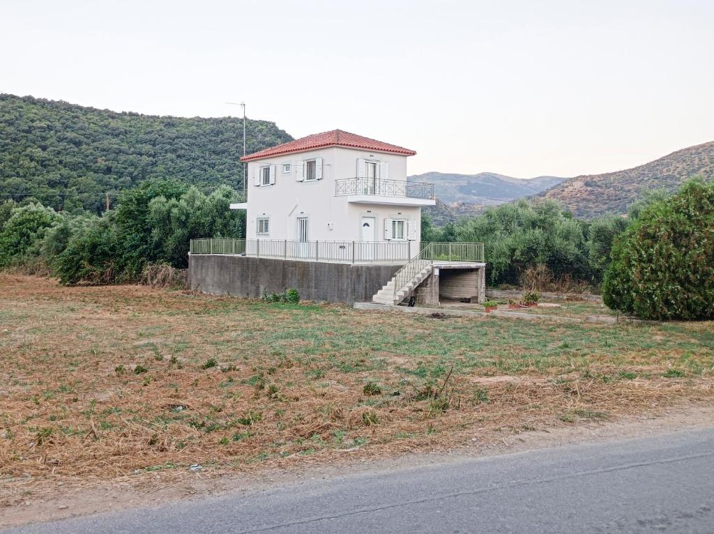 una casa blanca al lado de una carretera en Zoi's Hοuse.Vacation home in Mani near Vathi beach, en Vathí