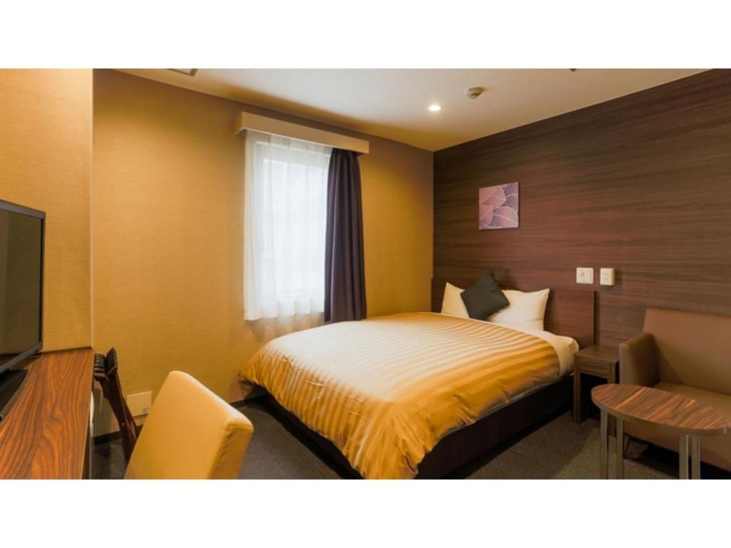 a hotel room with a bed and a television at Sun Royal Kawasaki - Vacation STAY 98721v in Kawasaki
