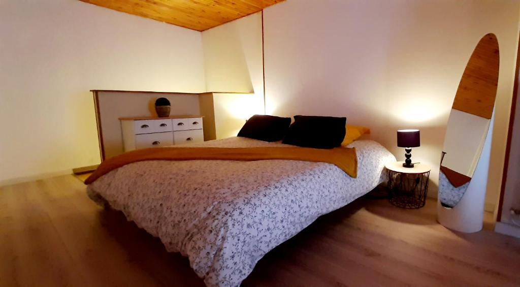 sypialnia z łóżkiem, komodą i lampą w obiekcie Les volets rouges du Moulin 