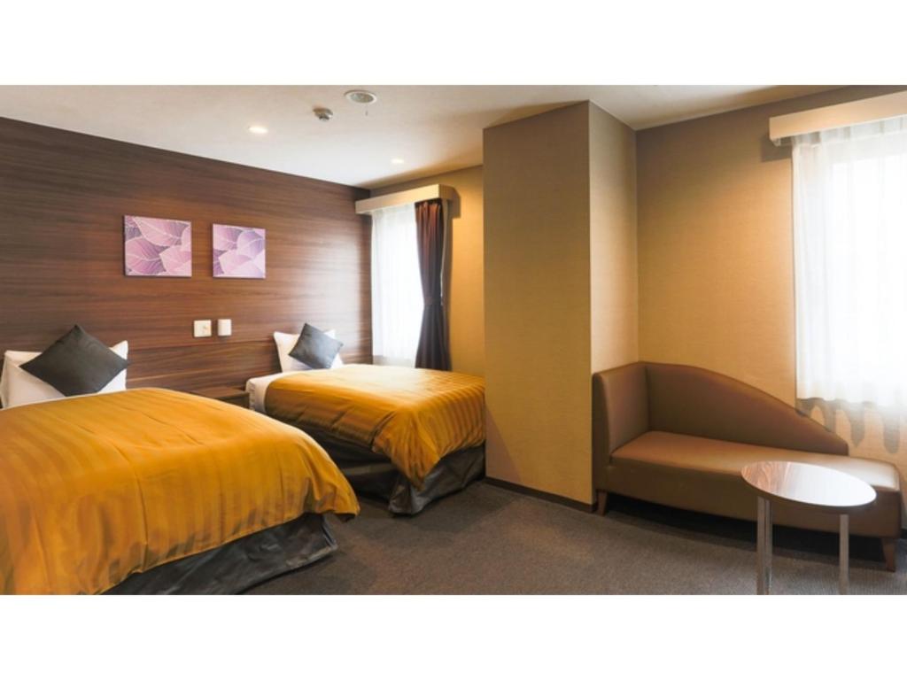 a hotel room with two beds and a chair at Sun Royal Kawasaki - Vacation STAY 98734v in Kawasaki