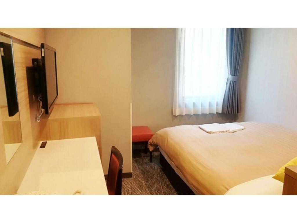 Habitación de hotel con 2 camas, mesa y TV. en Sun Royal Kawasaki - Vacation STAY 98672v, en Kawasaki