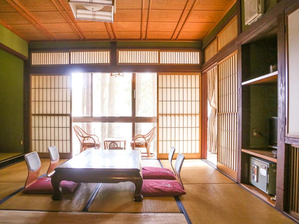 uma sala de jantar com uma mesa de madeira e cadeiras em Lupo Forest "GRAN FOREST Echizen Miyama" - Vacation STAY 06371v em Fukui