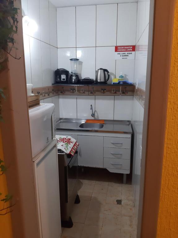 una pequeña cocina con fregadero y nevera. en Residencial BeachMar & Mael, en Florianópolis