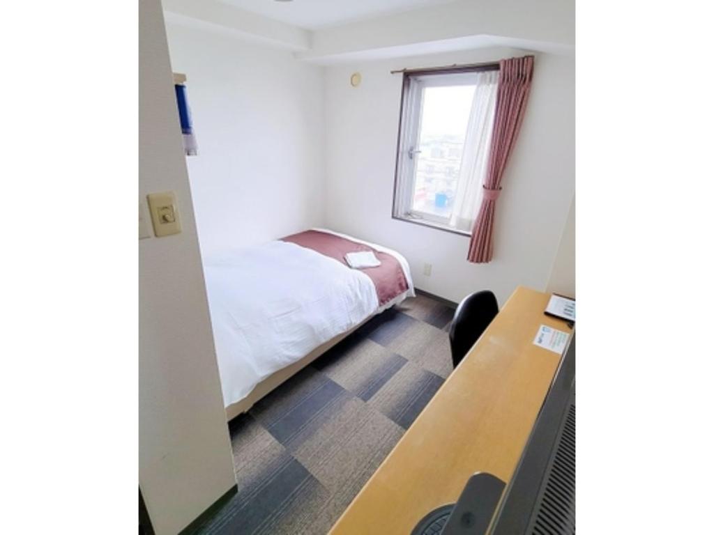 a small room with a bed and a desk at Hotel Yukita - Vacation STAY 20929v in Sapporo