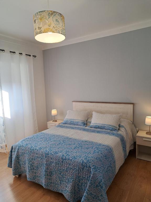 貝雅的住宿－Beja Garden，一间卧室配有一张带蓝色棉被的床