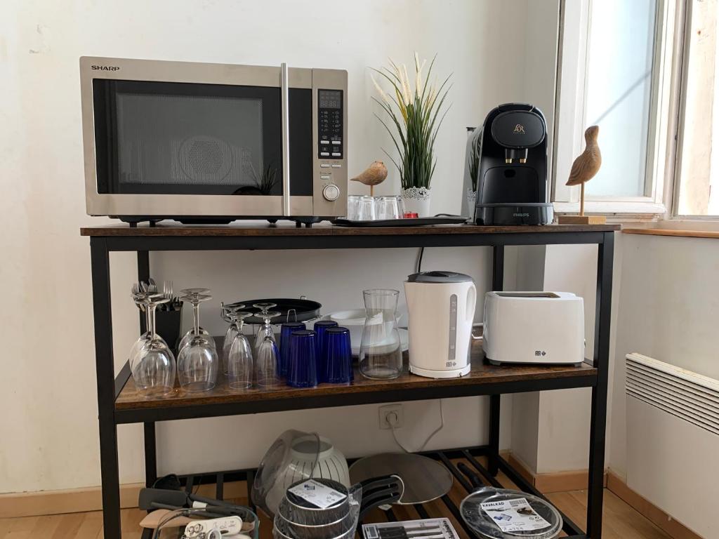 kuchenka mikrofalowa na półce z urządzeniami w obiekcie Biarritz centre, près Avenue de Verdun, cosy Apt 2 pieces , salon , chambre séparé, rue très calme à 10 minutes à pied de la grande plage w Biarritz