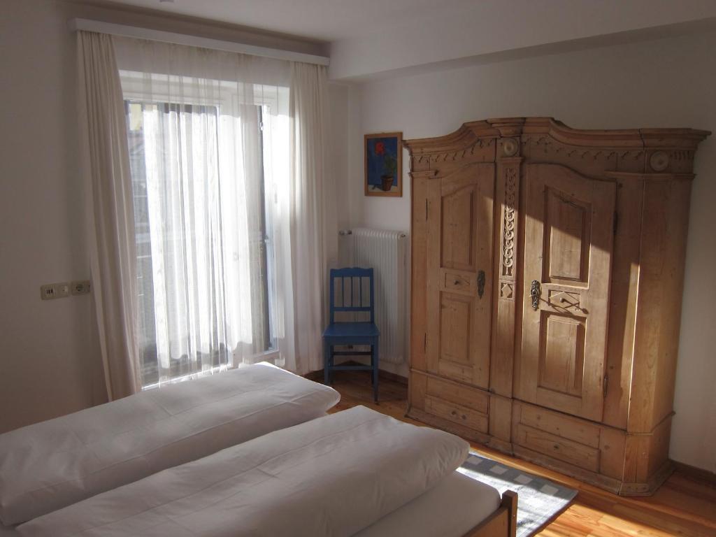 シュルンスにあるAppartement Dorfplatzのベッドルーム1室(ベッド2台、大きな木製キャビネット付)