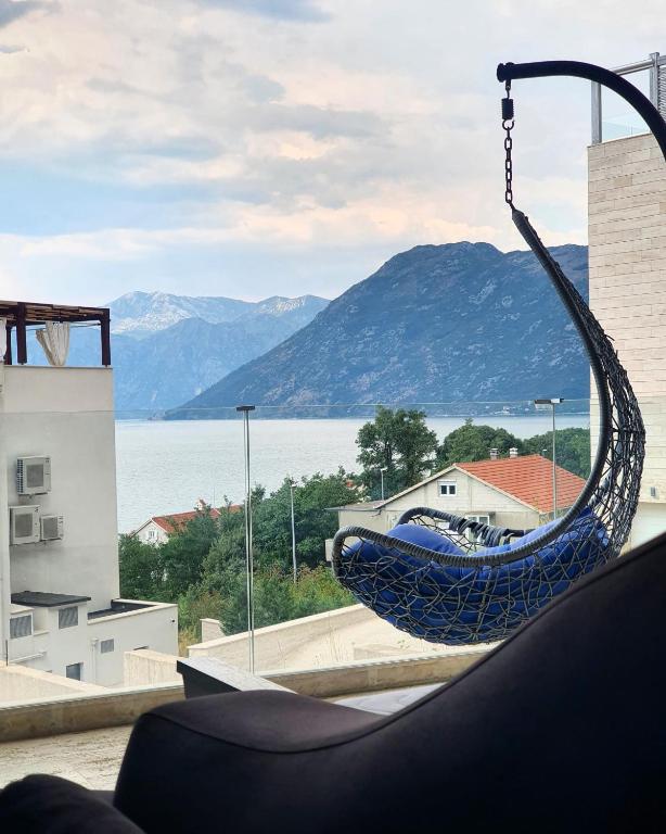 a hammock on a building with a view of the water at Apartment Sunset in Kotor