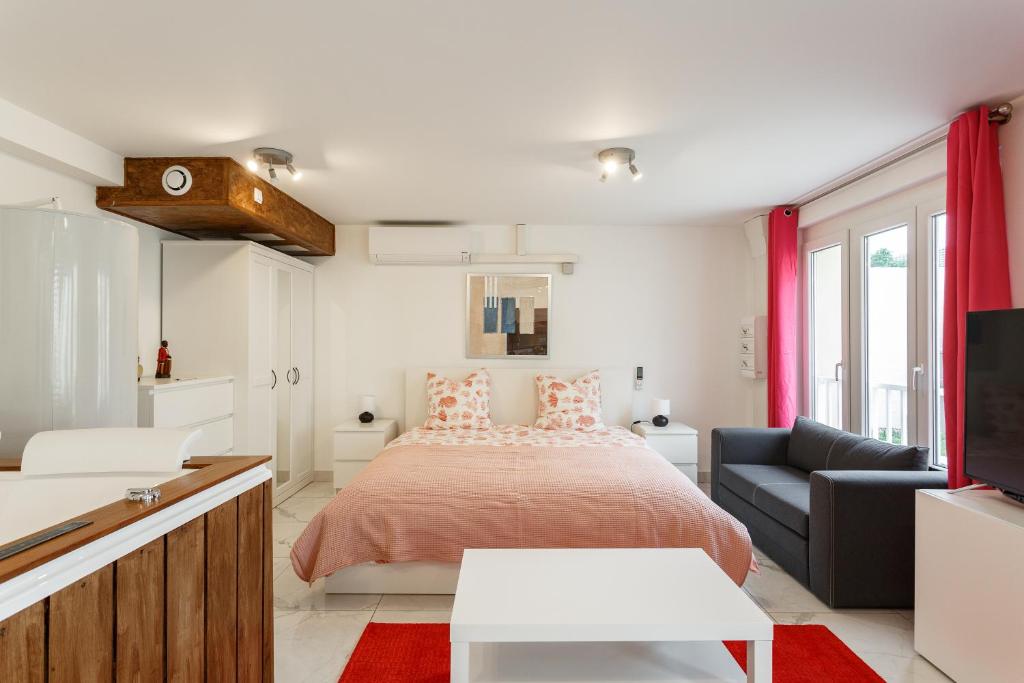 una camera con letto e divano di Blanc Mesnil Nid d'amour a Le Blanc-Mesnil