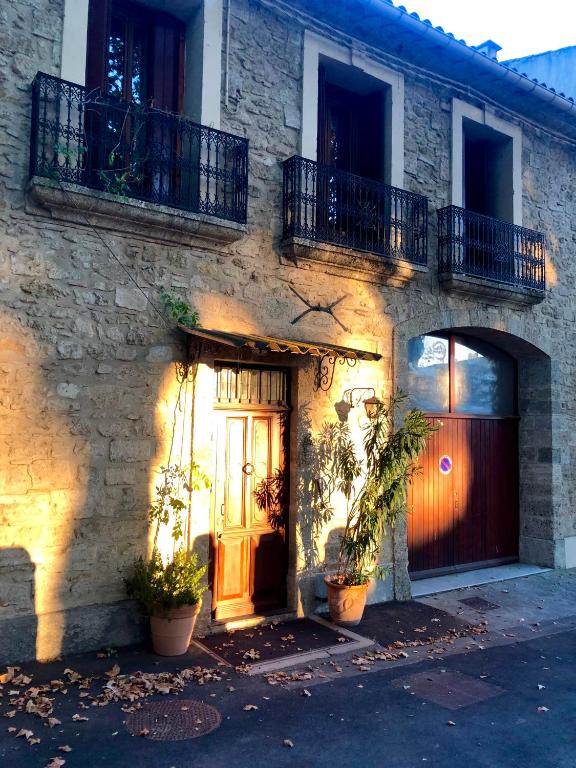 a stone house with a door and plants in front of it at Au bout du pré in Pézenas