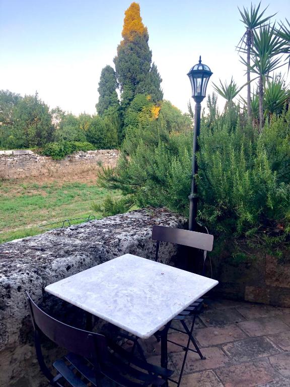 a table and a street light sitting next to a lamp at Au bout du pré in Pézenas