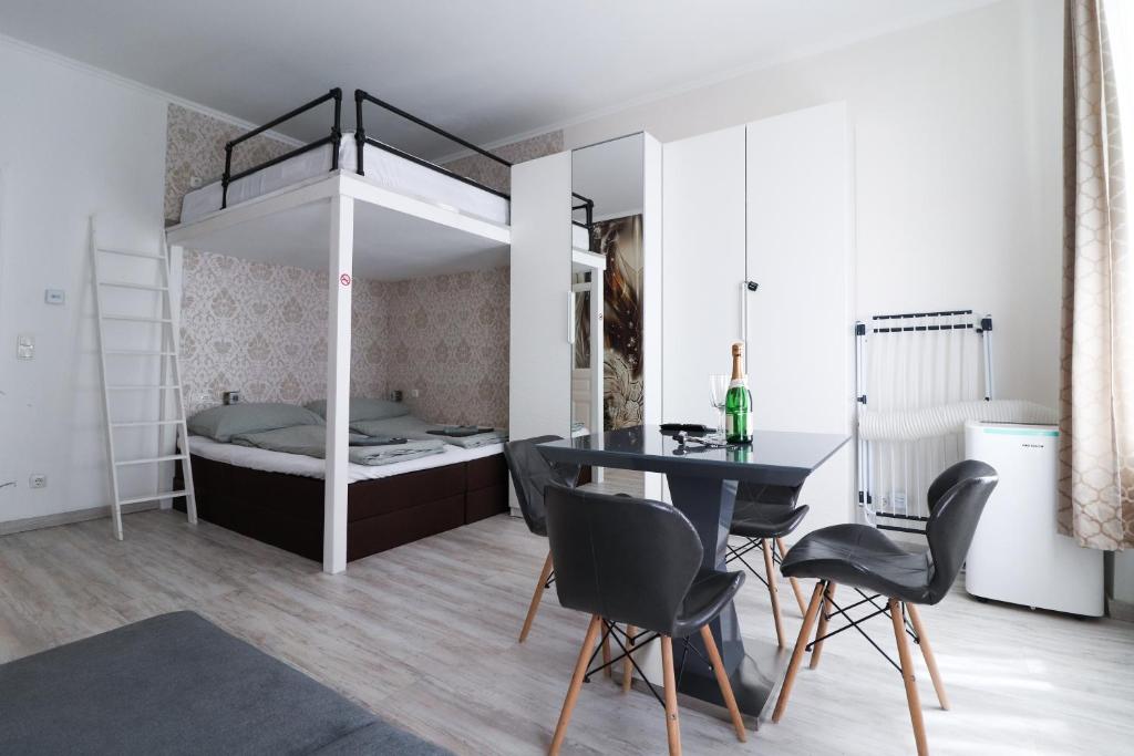 a bedroom with a bunk bed and a dining table and chairs at CozyNite Premium Apartment Favoriten 1 in Vienna
