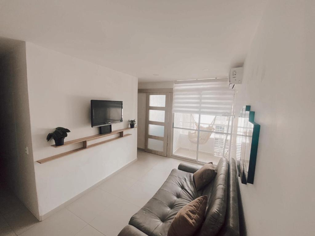 sala de estar con sofá y TV en lovely 2 bedroom Apartment with pool and gym, en Cartagena de Indias