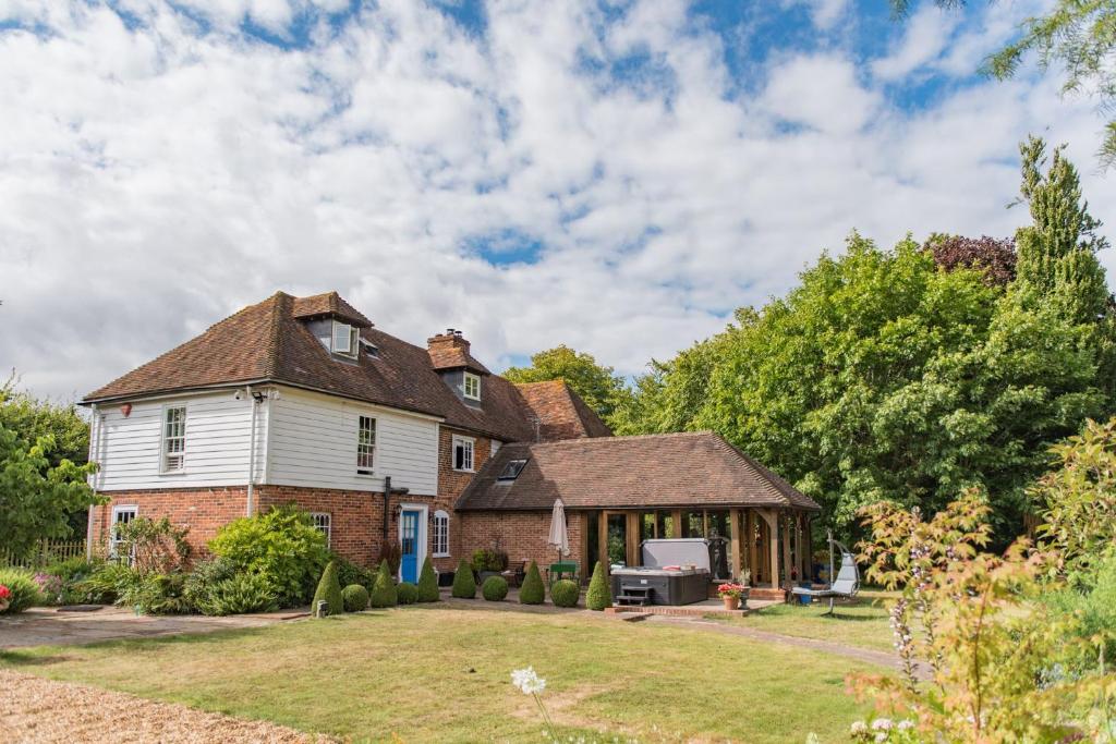 an old house with a yard and a house at Bacchus by Bloom Stays in Canterbury