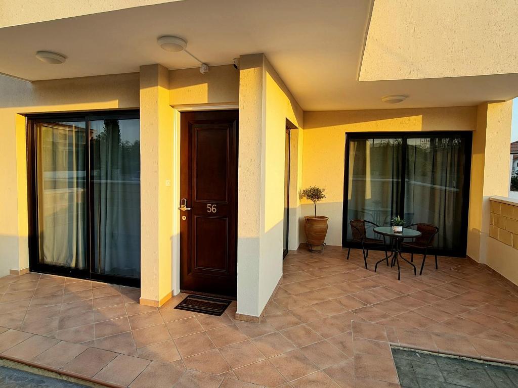 a front door of a house with yellow walls at PylaApts - Apartments near the beach in Pyla