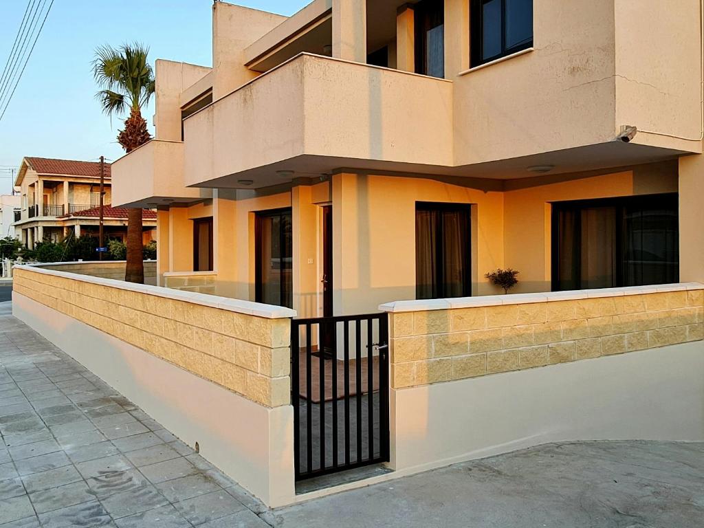 a building with a fence on the side of it at PylaApts - Apartments near the beach in Pyla