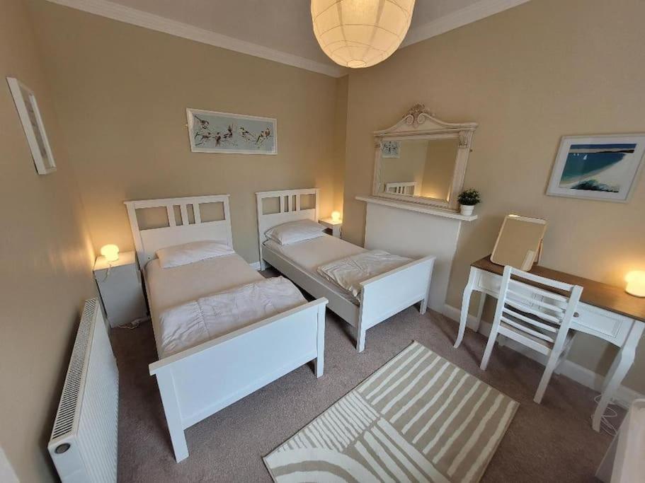 a bedroom with two beds and a desk and a mirror at Character cottage in centre of Moffat in Moffat