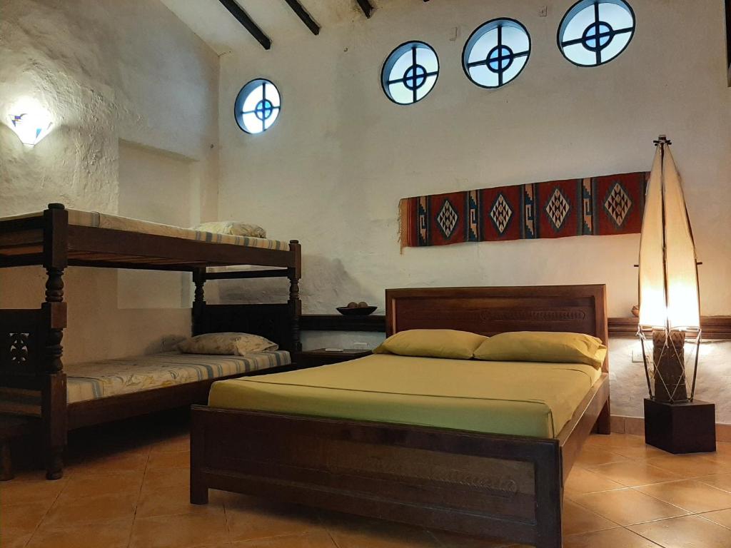 a bedroom with two beds and two windows and a lamp at Casa Constantino in Rivera