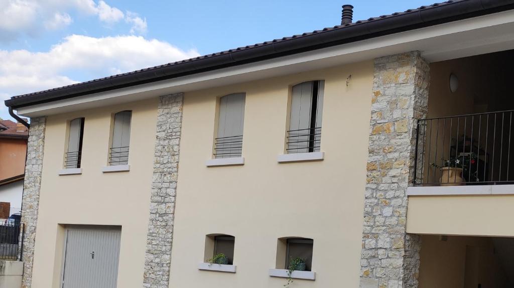 a white building with windows and a balcony at Casetta Morris in Valdobbiadene