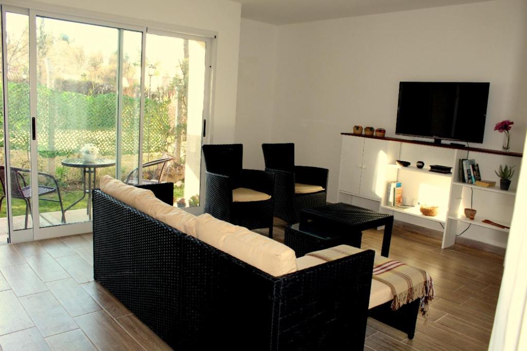 a living room with a couch and chairs and a television at Casita en Chacras in Ciudad Lujan de Cuyo