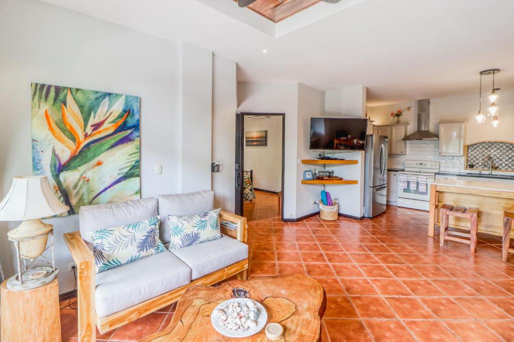 ein Wohnzimmer mit einem Sofa und einer Küche in der Unterkunft Casa Mimosa in Playa Flamingo
