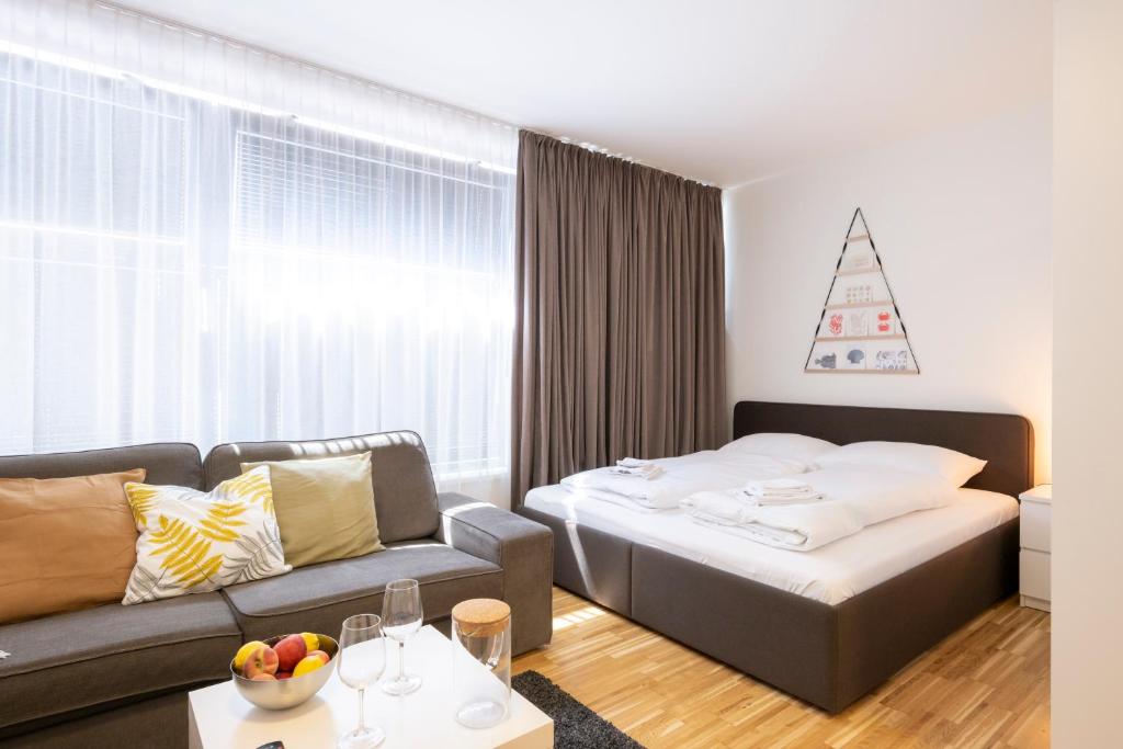 a living room with a bed and a couch at Modern City Hideaway Graz in Graz