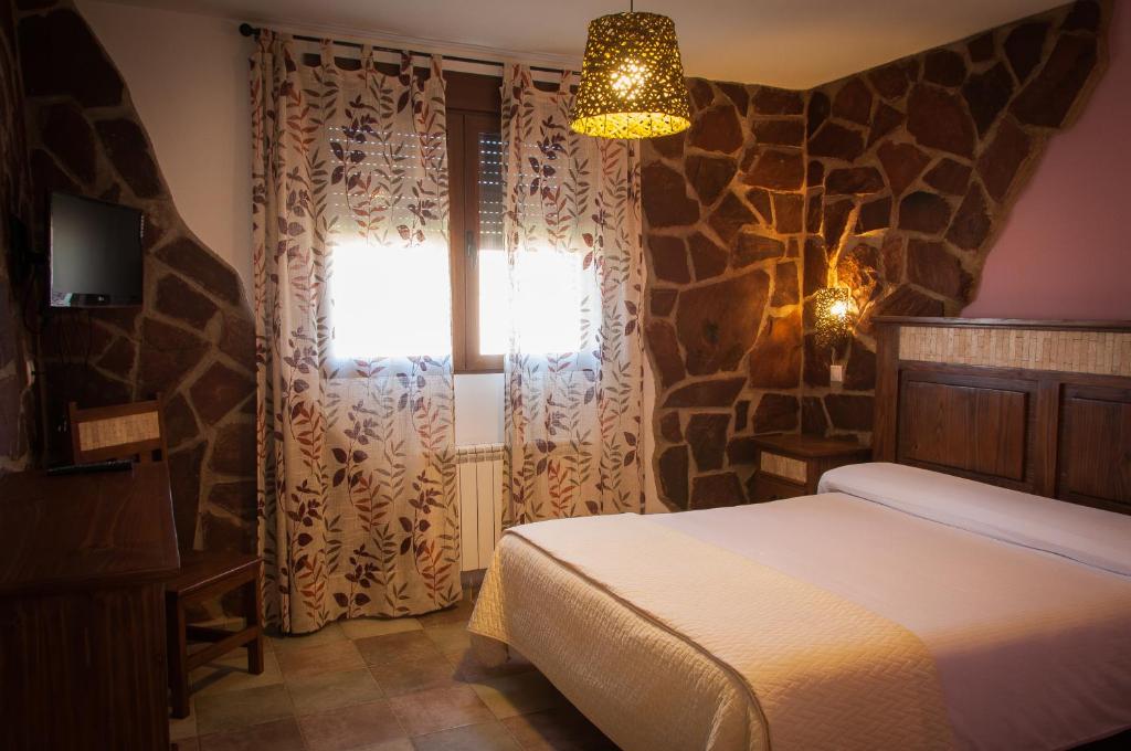 a bedroom with a bed and a window at Casa Rural La Dueña in El Pobo de Dueñas