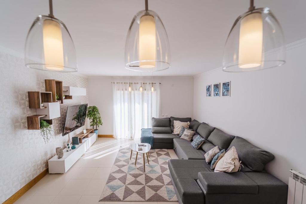 uma sala de estar com um sofá e uma mesa em Farol Beach Place na Nazaré