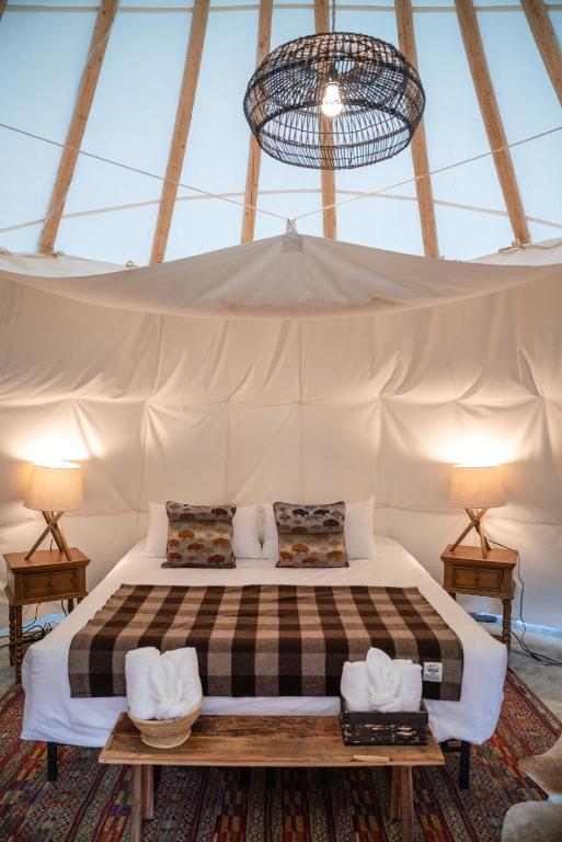 a bedroom with a bed in a tent at Dreamcatcher Tipi Hotel in Gardiner