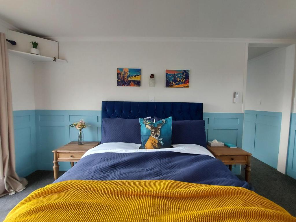 - un lit avec une tête de lit bleue dans une chambre dans l'établissement DuxHouse BnB, à Taihape