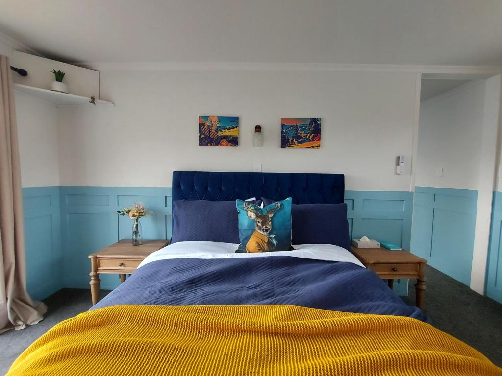 a bed with a blue headboard in a bedroom at DuxHouse BnB in Taihape