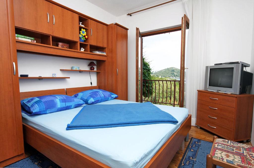 sypialnia z łóżkiem, telewizorem i oknem w obiekcie Apartments by the sea Sobra, Mljet - 4898 w mieście Babino Polje