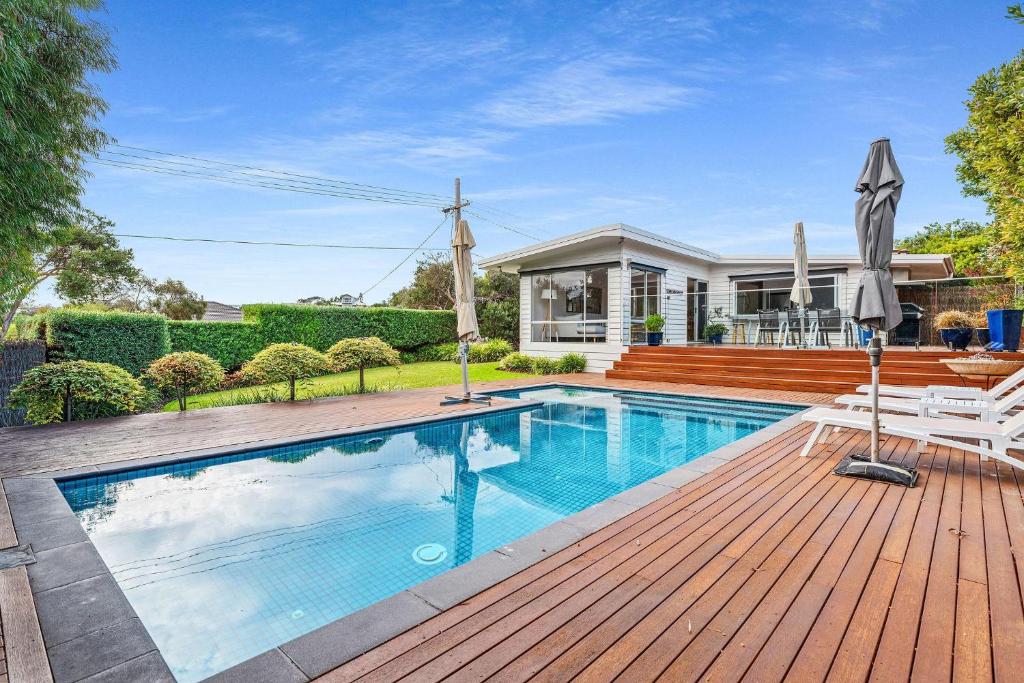 a swimming pool on a wooden deck next to a house at Holiday Haven with Pool in Sorrento
