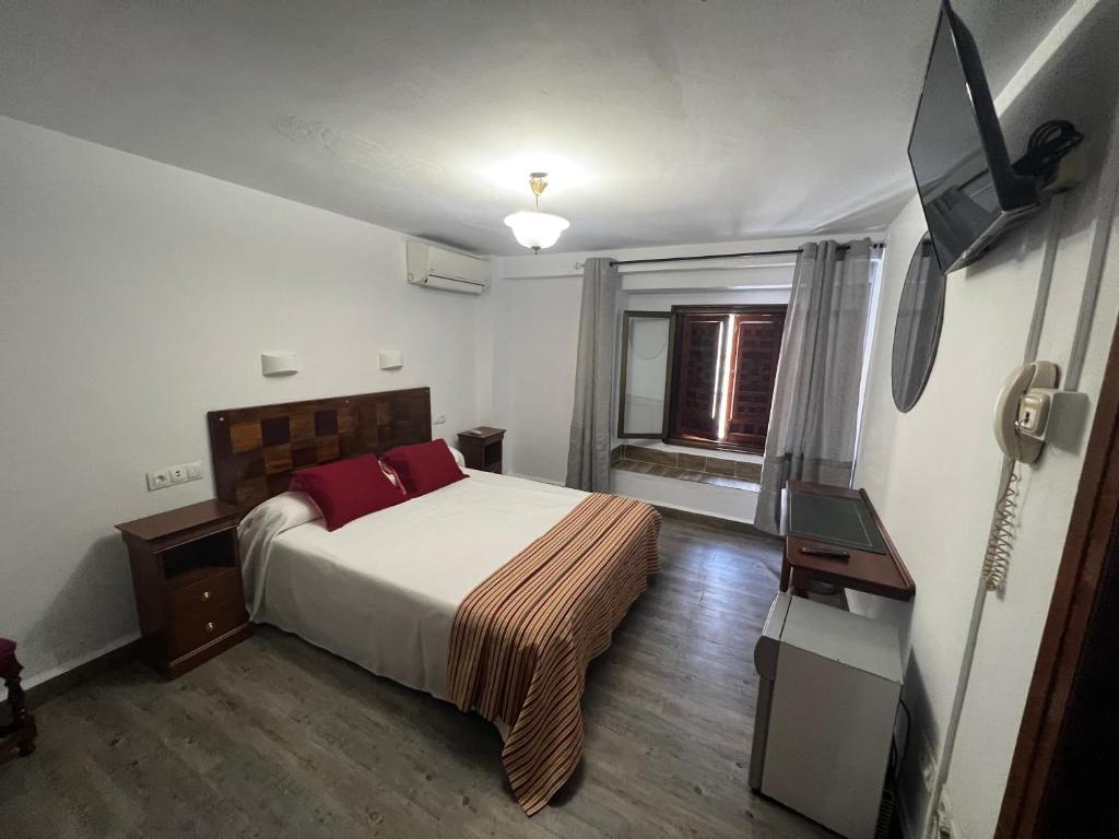 una camera con letto e TV a schermo piatto di Hostal Colon Antequera ad Antequera