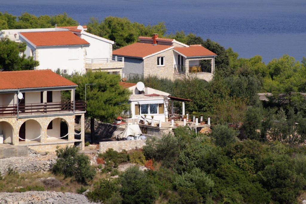 a group of houses on a hill next to the ocean at Apartments with a parking space Rogac, Solta - 5165 in Grohote