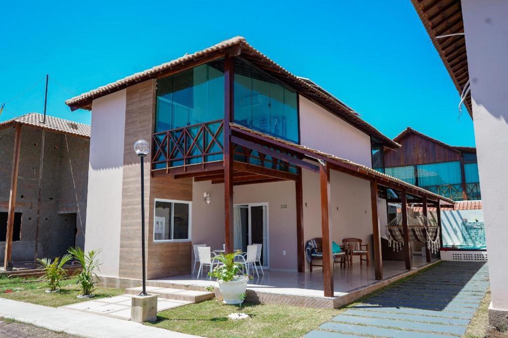 ein Haus mit Glasfenstern und einer Terrasse in der Unterkunft Casa na Praia dos Carneiros/PE. Cond. Village IV. in Tamandaré