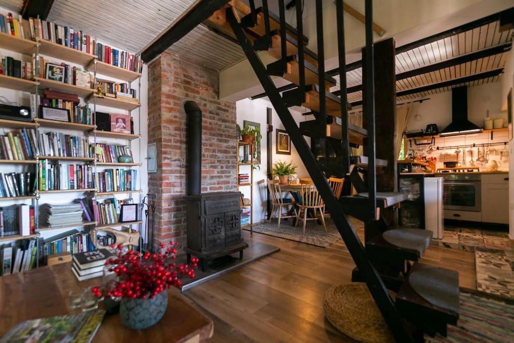 uma sala de estar com uma escada em espiral e uma lareira em Cottage Veronika em Velika Gorica