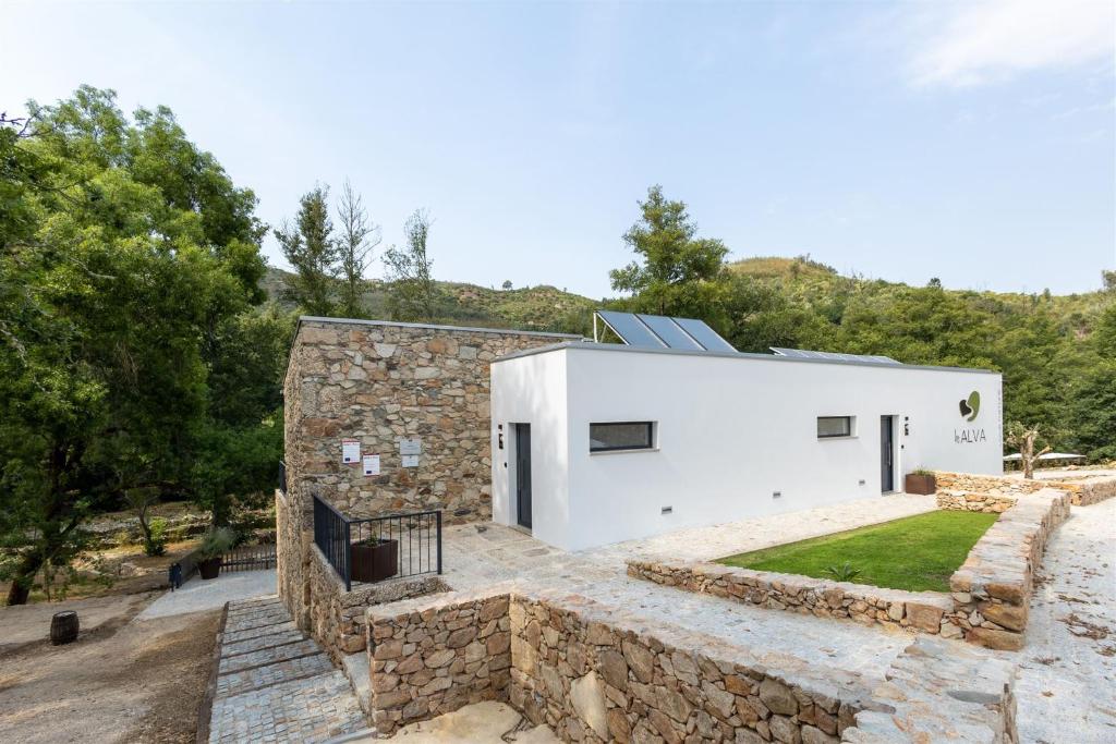 a contemporary house with a stone wall at Be Alva in Oliveira do Hospital