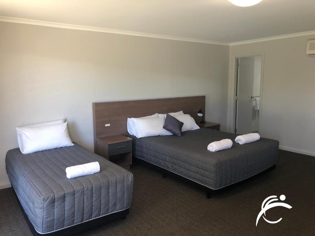 Habitación de hotel con 2 camas y toallas. en Coro Club Motel, en Griffith