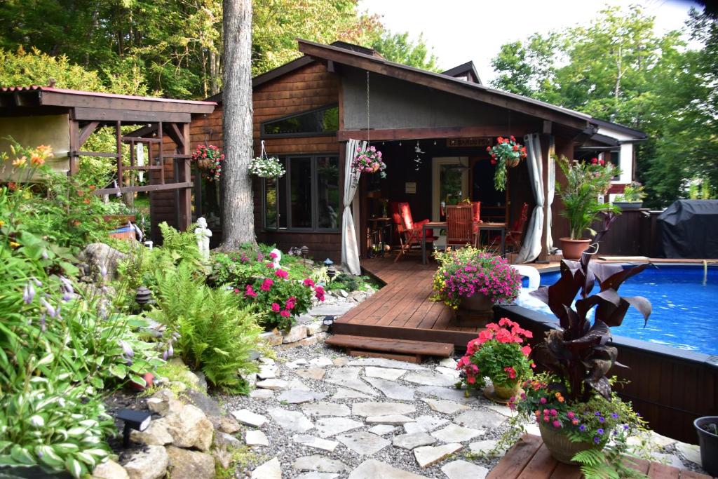 a house with a deck and a swimming pool at PETIT COIN DE PARADIS in Sainte Anne des Lacs