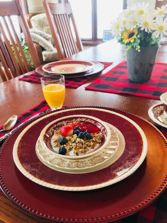 a table with a plate of food and a glass of orange juice at PETIT COIN DE PARADIS in Sainte Anne des Lacs