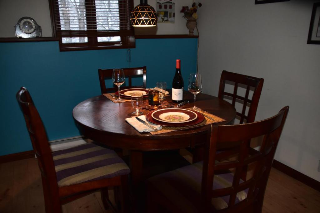 a dining room table with a bottle of wine and glasses at PETIT COIN DE PARADIS in Sainte Anne des Lacs