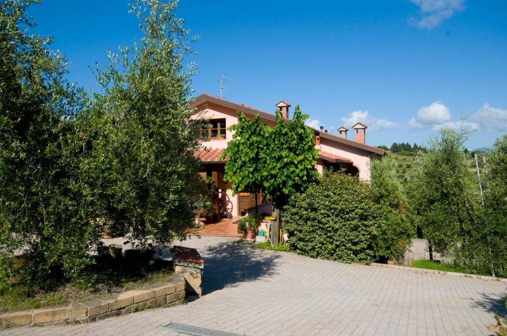 a house with trees and a brick driveway at Agriturismo De Santis in Castiglioncello