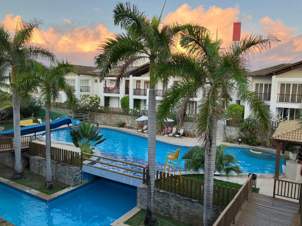 vista para a piscina num resort com palmeiras em Farol do Tree Bies em Subaúma