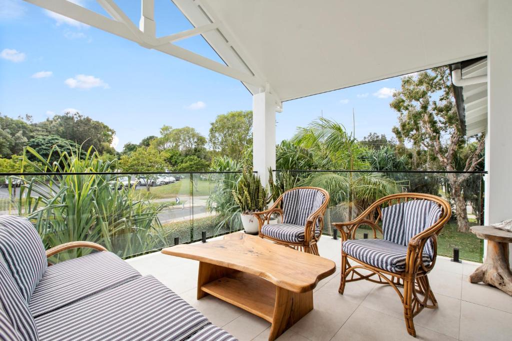 eine Terrasse mit 2 Stühlen und einem Holztisch auf dem Balkon in der Unterkunft Byron Bay Accom Unit 6 70 Lawson Street - Atlantis in Byron Bay