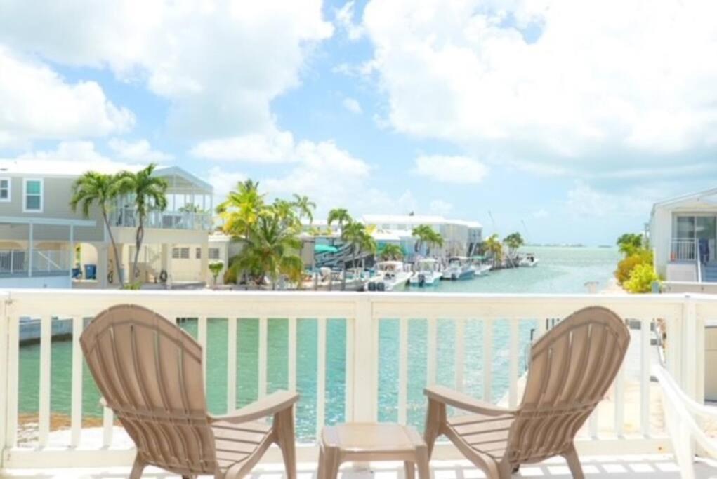 two chairs and a table on a balcony overlooking the water at Island Oasis ~ YOUR Paradise Awaits! in Cudjoe Key