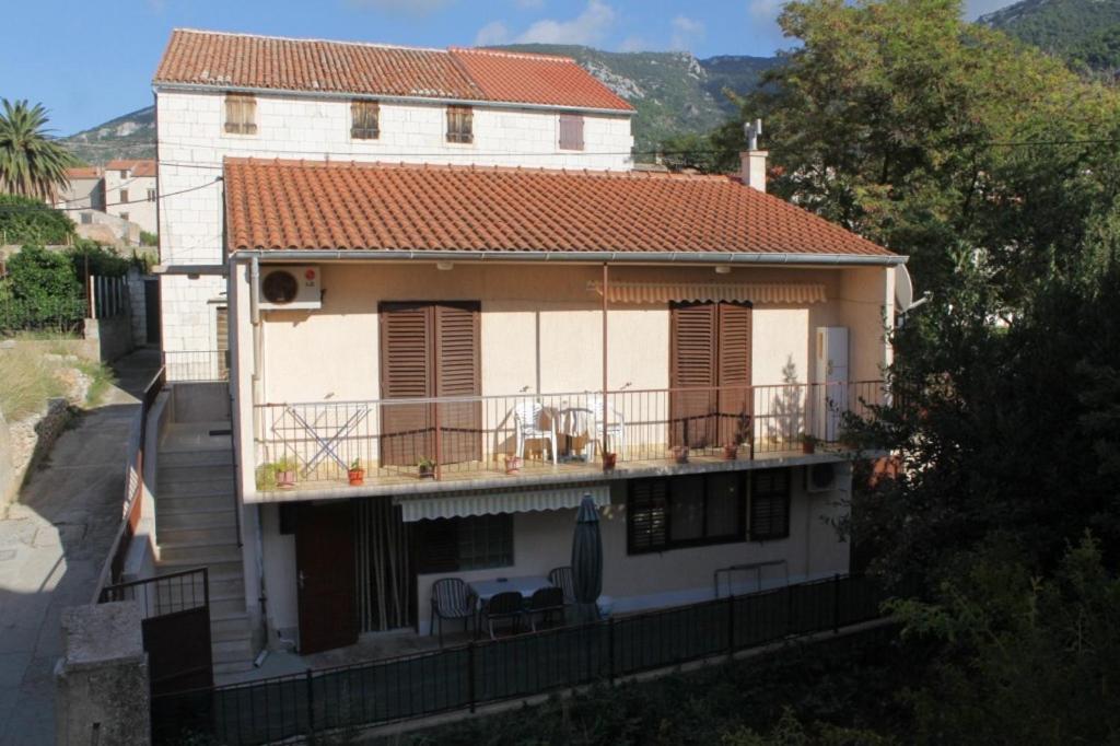 a large white house with a balcony in front at Apartments and rooms by the sea Komiza, Vis - 8841 in Komiža